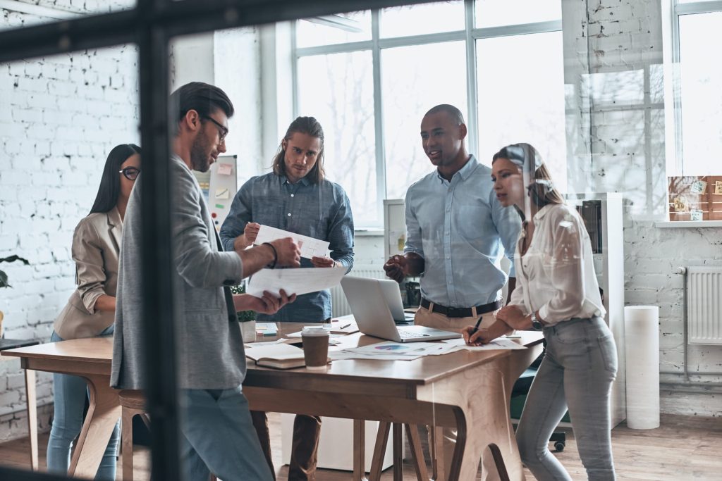 Grupo de profesionales discutiendo un proyecto en una oficina estilo loft.